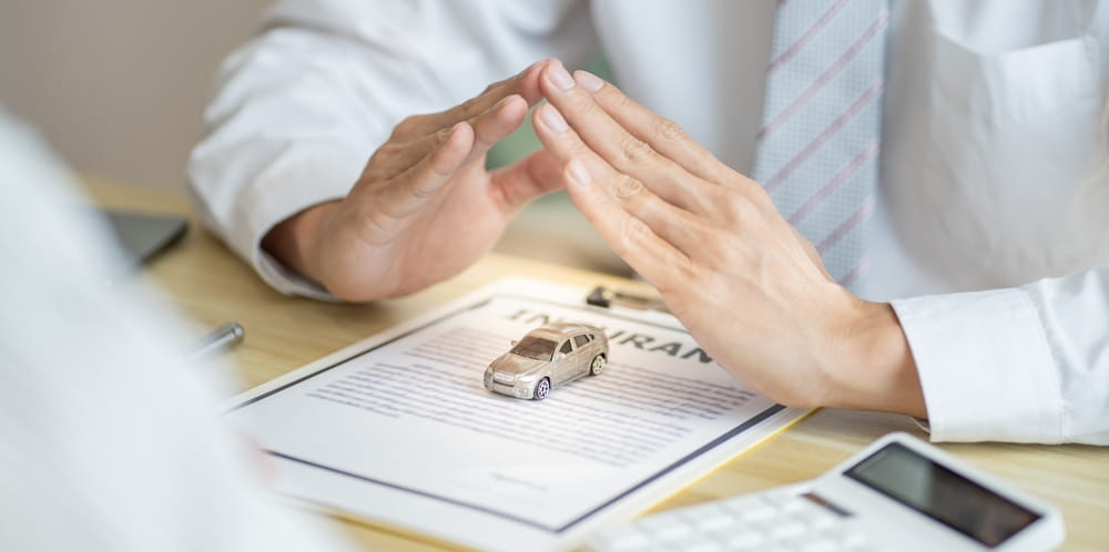 A toy car laying on insurance papers