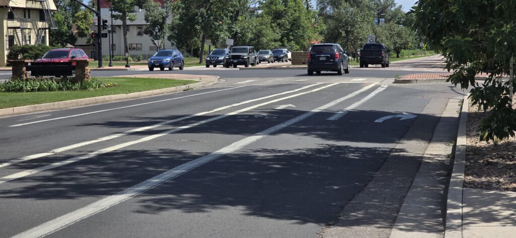 A buffered bike lane along Cascade Avenue near Uintah Street. The buffered bike lane offers extra distance from traffic by adding a third white line to the lane, marking off a bigger buffer zone than a standard bike lane.