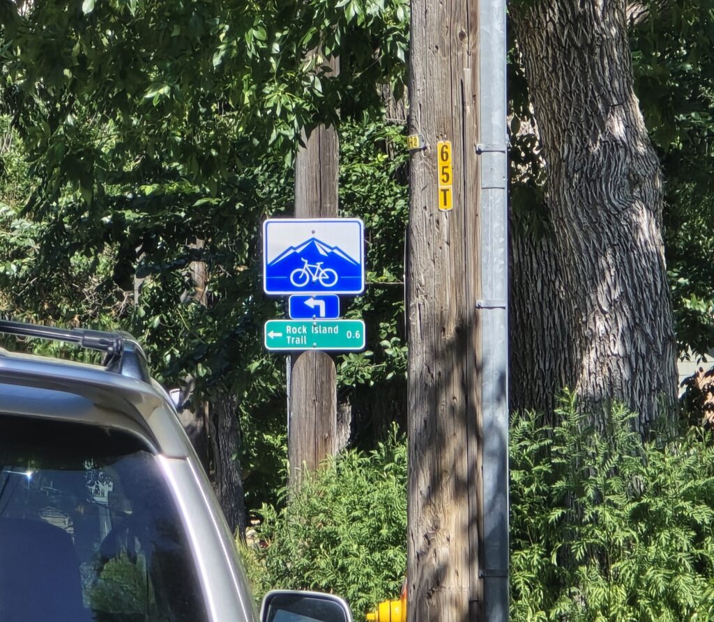 Closeup: A Colorado Springs "Wayfinder" blue and white bicycle route sign along Fontanero Street.