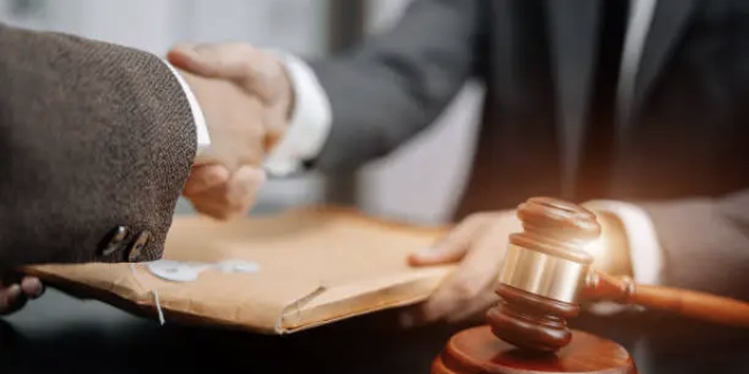 Cliente y abogado de lesiones personales en Colorado Springs sellan acuerdo legal junto a mazo de juez