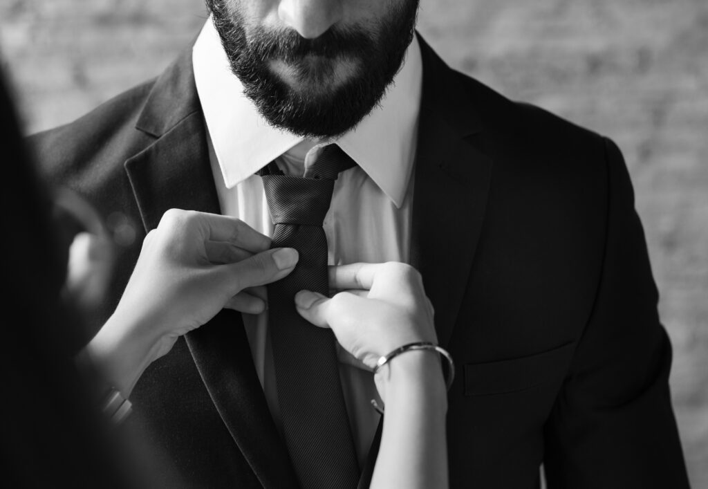 Persona ajustando una corbata antes de asistir a una audiencia en la corte, reflejando la importancia de una apariencia profesional y respetuosa ante el juez.