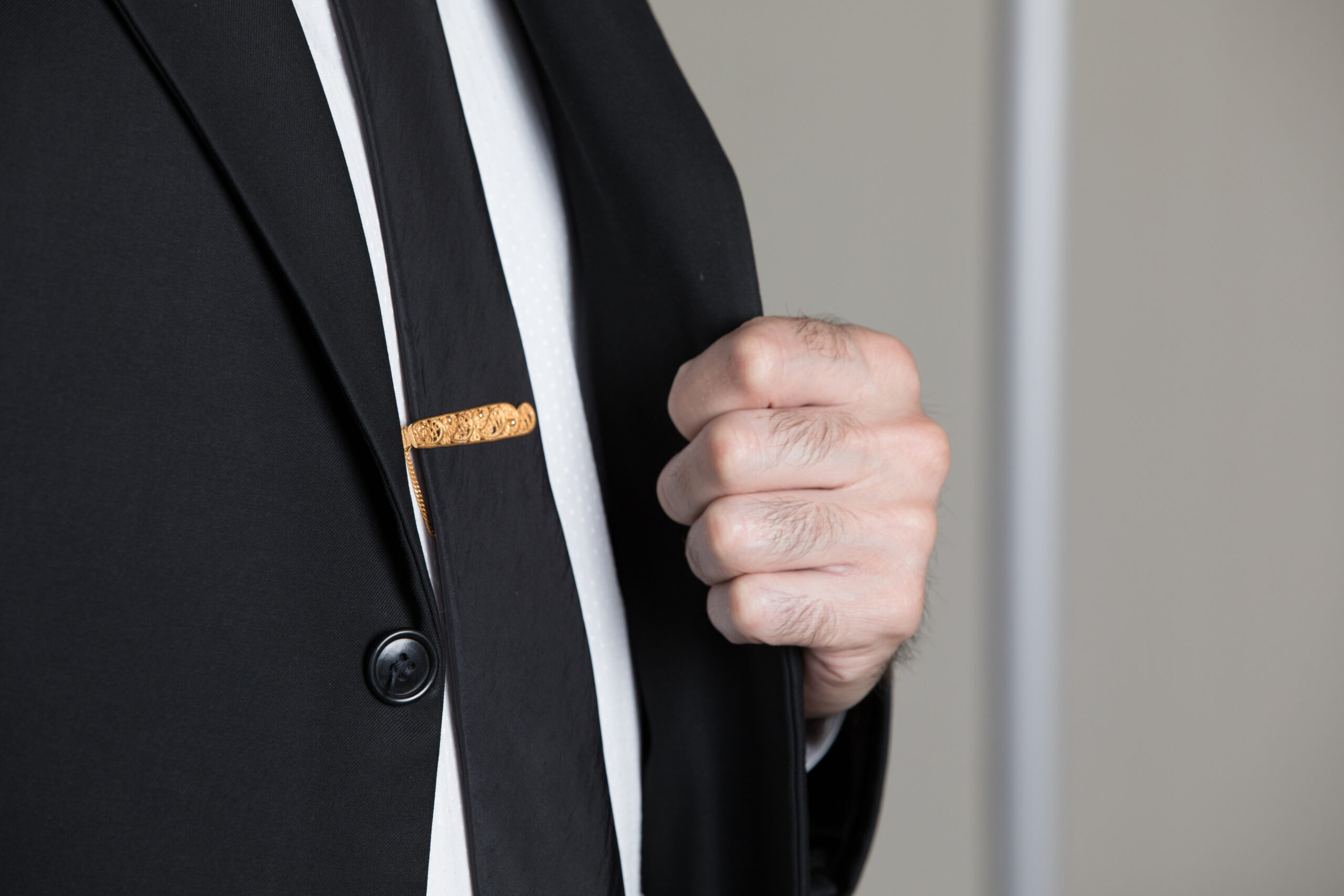 Hombre con traje formal ajustando su saco antes de una audiencia judicial, ejemplo de vestimenta apropiada para comparecer ante la corte.