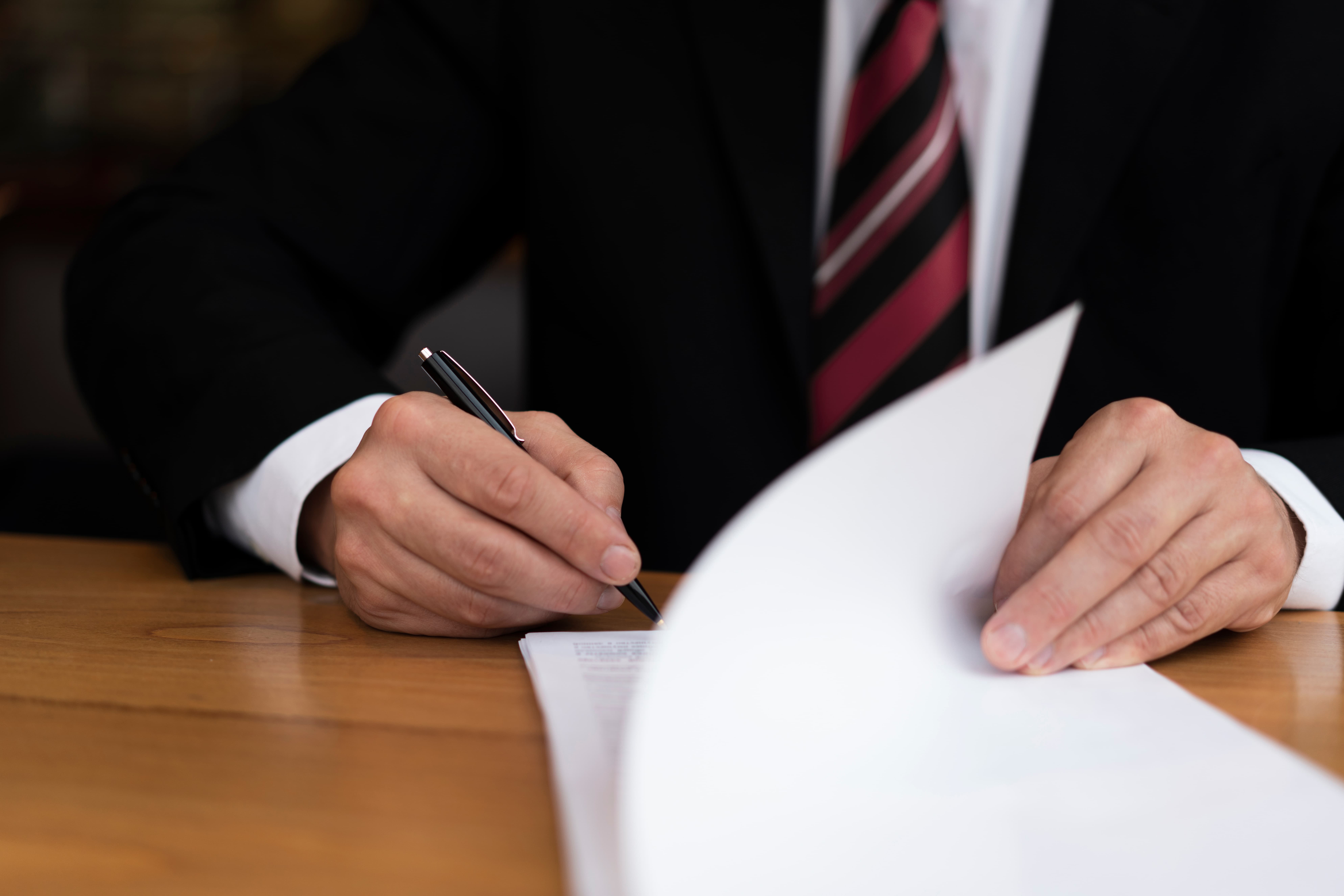 Persona firmando un acuerdo extrajudicial de lesiones personales para resolver una reclamación de compensación sin juicio.